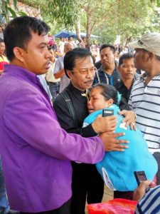 Jumaga Nadeak memeluk untuk menenangkan ibu korban.